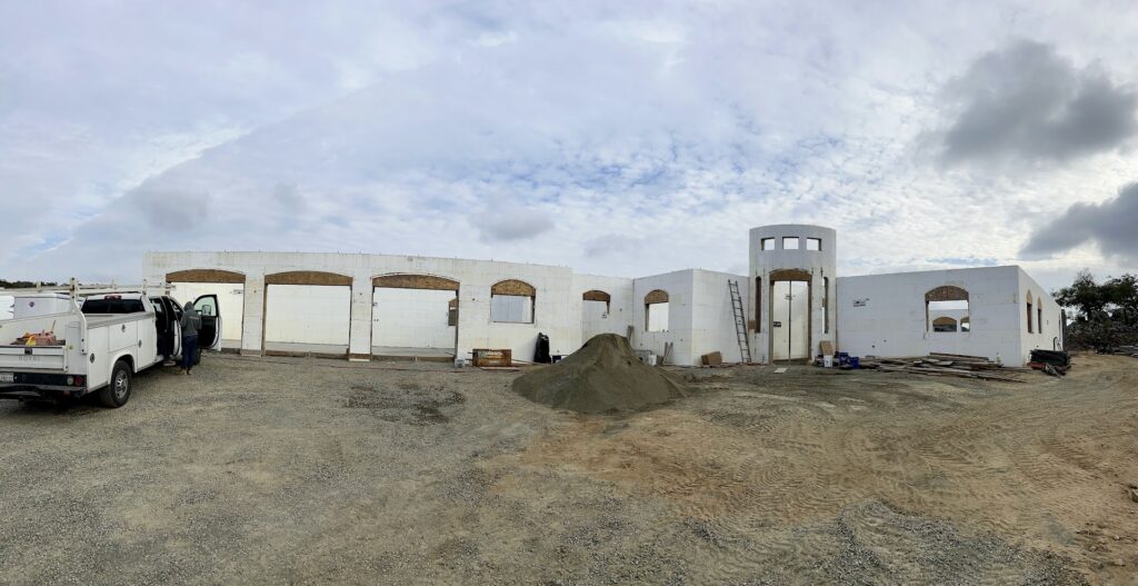Full ICF shell of the Koll custom home with arched openings and round entry tower